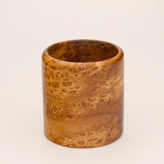 Amber colored River Tamarind Burl wood shot glass on white background