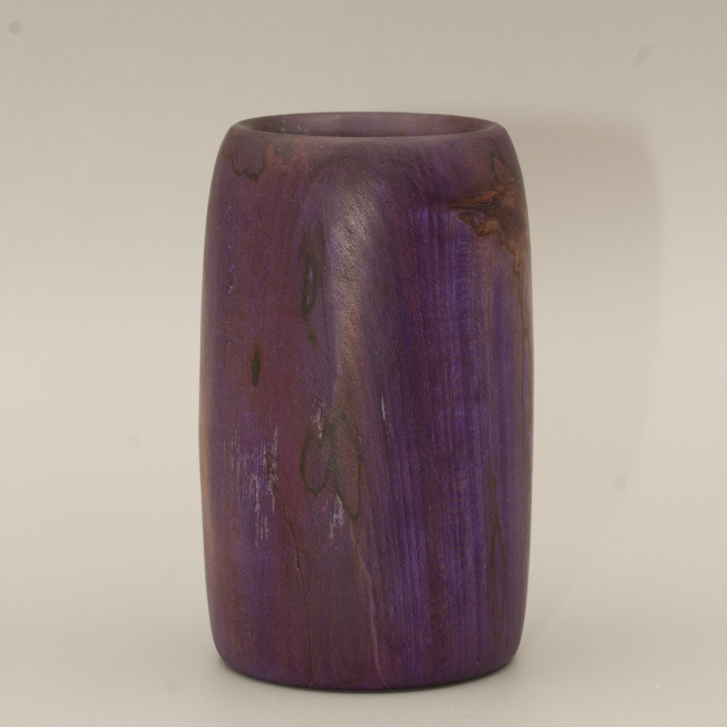 Amethyst colored wood shot glass against white background