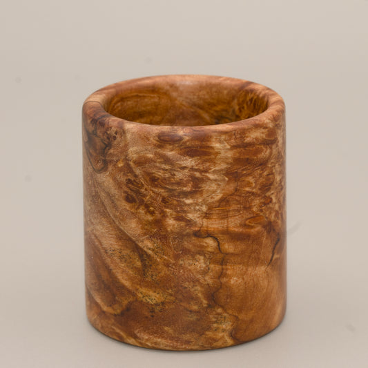 Maple burl end cap shot glass against light background
