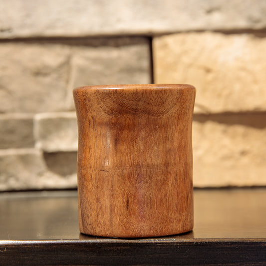 Another side of The Quiet Return shot glass, showing lighter brown grain, subtle darker figuring, and the rounded, slightly protruding rim.