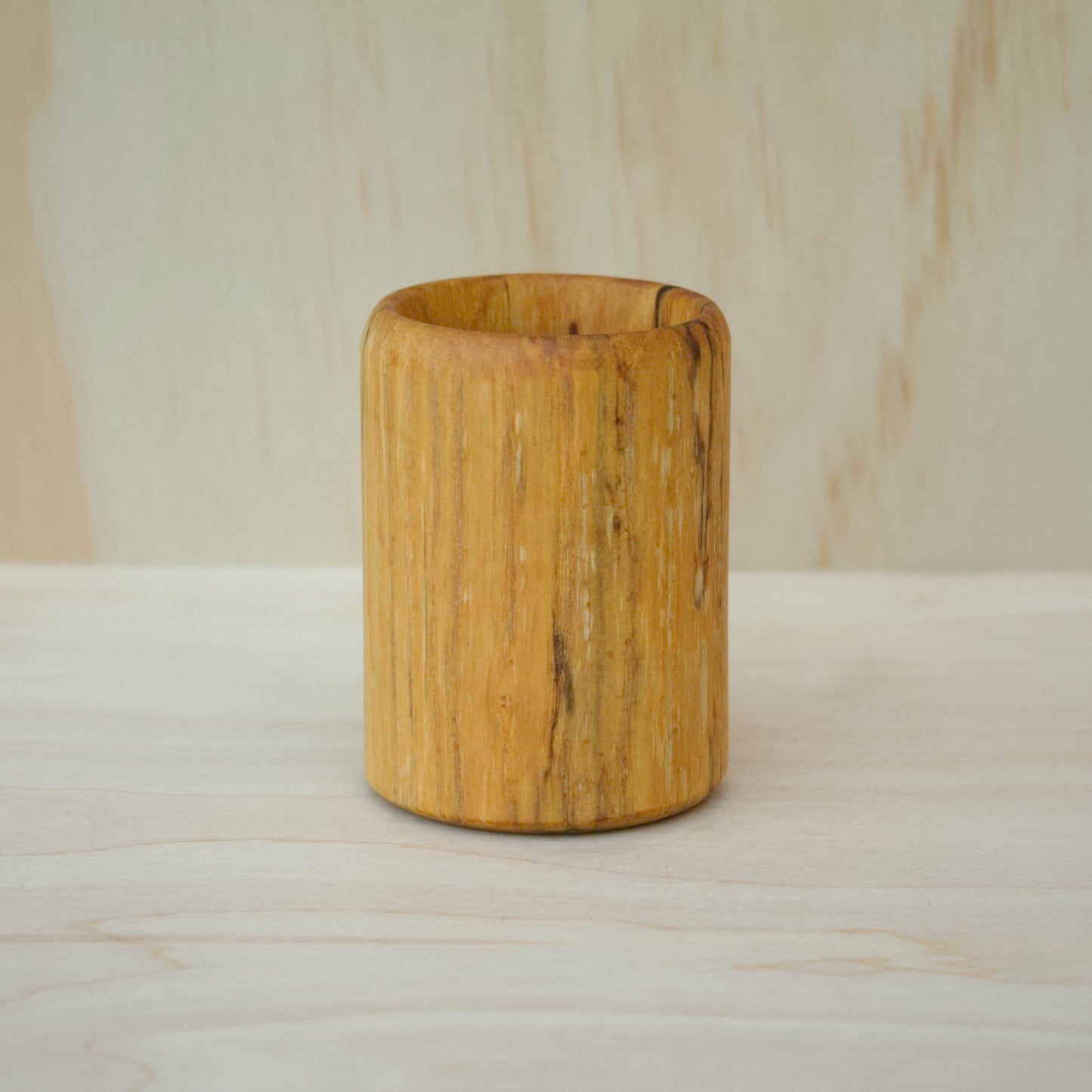 Wooden cup on a wooden surface with a neutral background