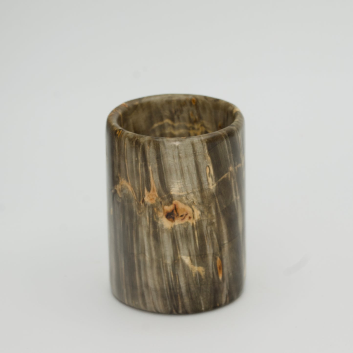Green boxer elder burl shot glass against white background