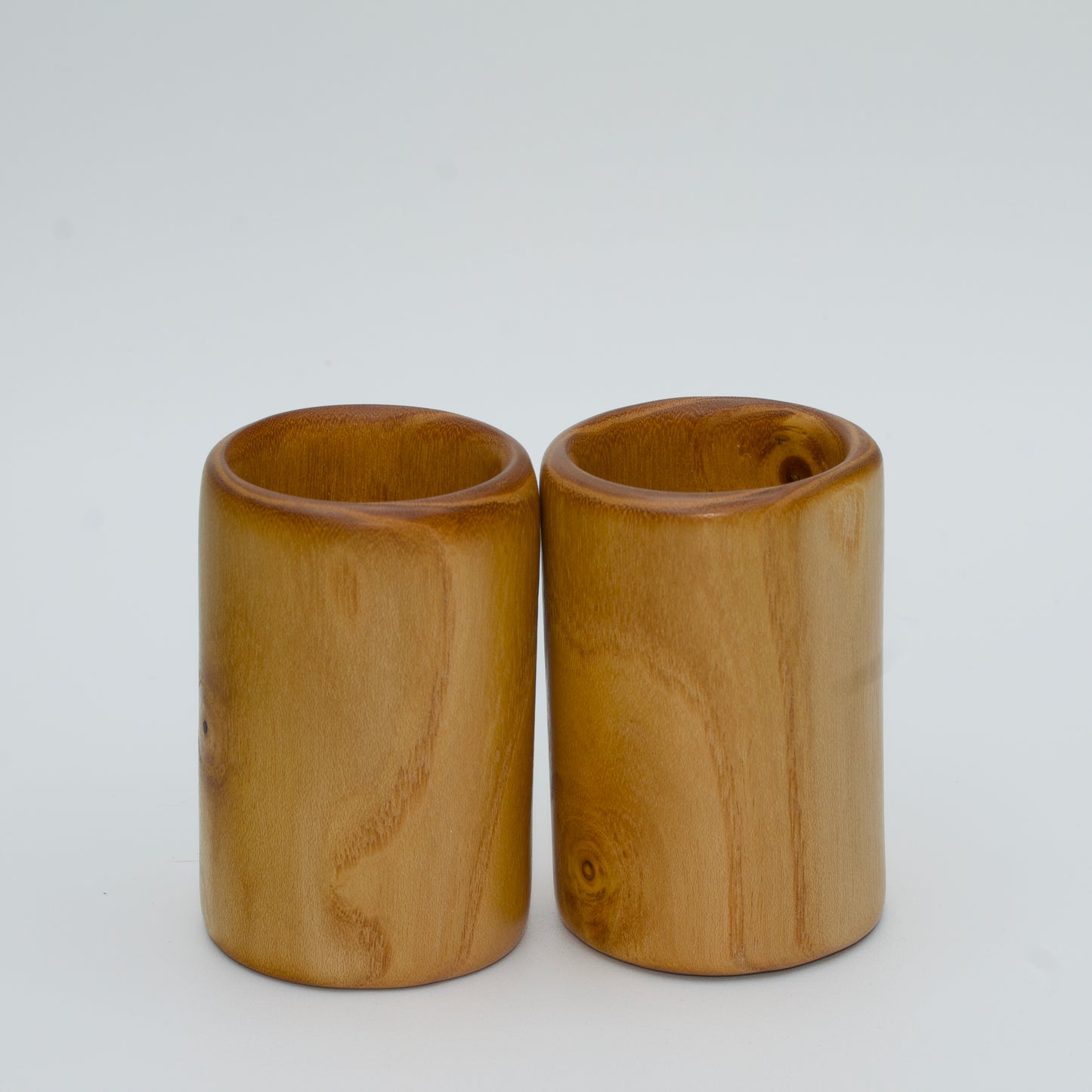 Pair of white mulberry shot glasses with orange glow
