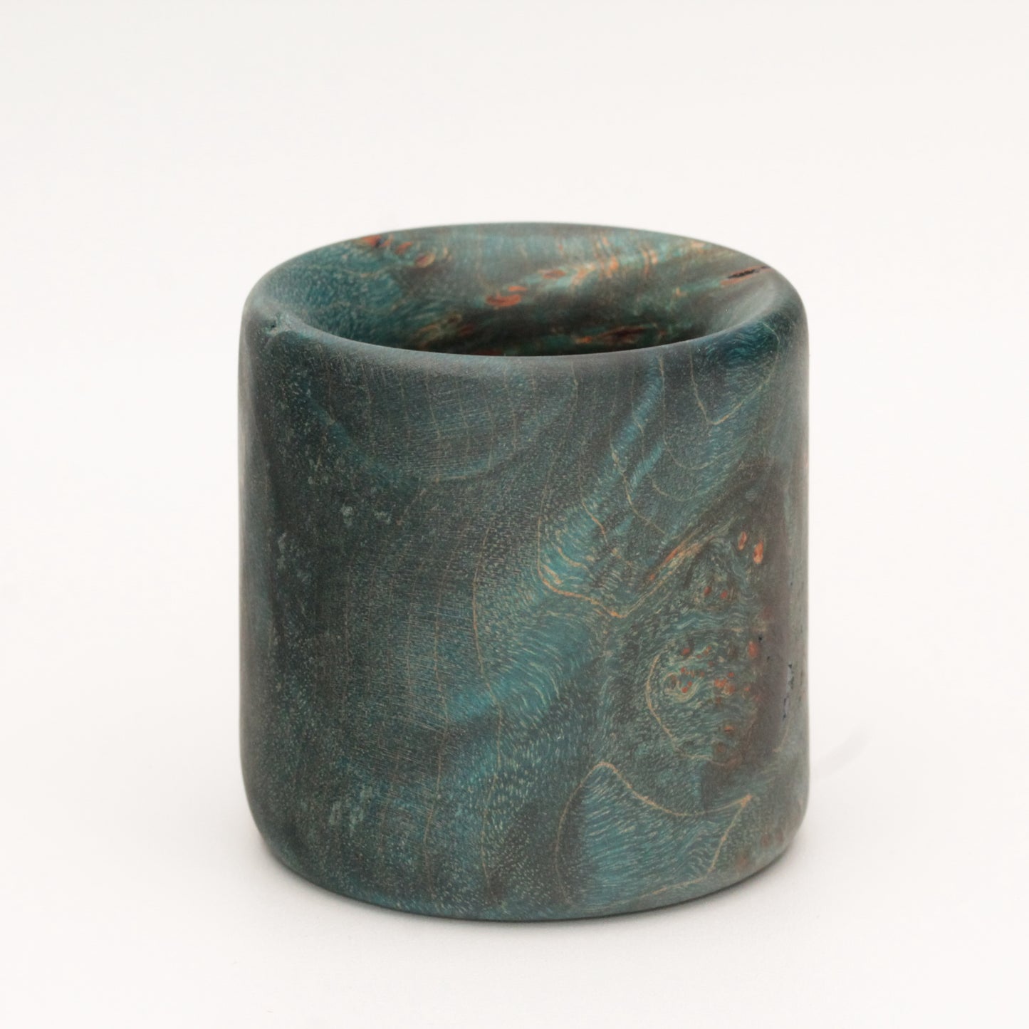 Blue maple burl wood shot glass against white background