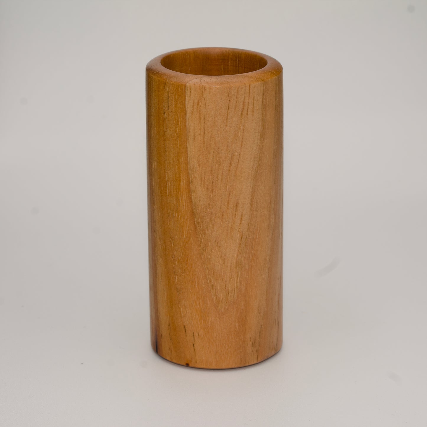 Tall pecan wood shot glass against white background