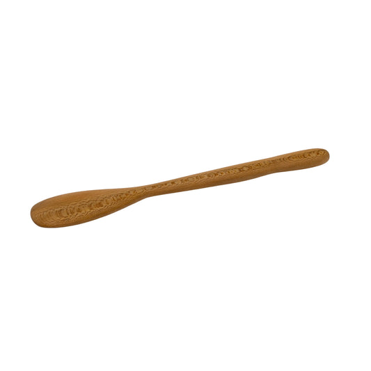 Wooden spoon with intricate carvings on a beige background