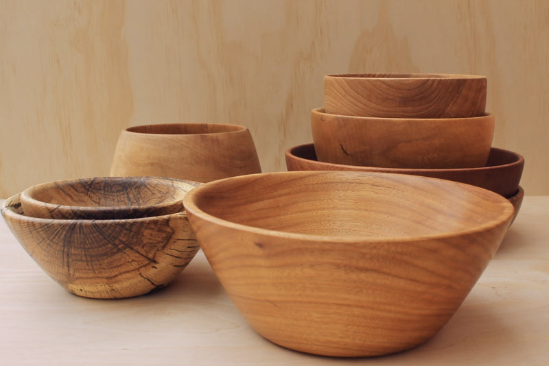 hand made wooden rice bowls, salad bowls, and decorative bowls on a light wooden background