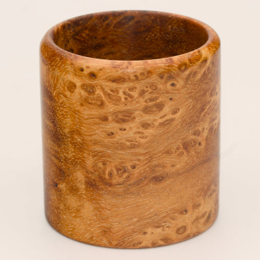 Amber colored River Tamarind Burl wood shot glass on white background