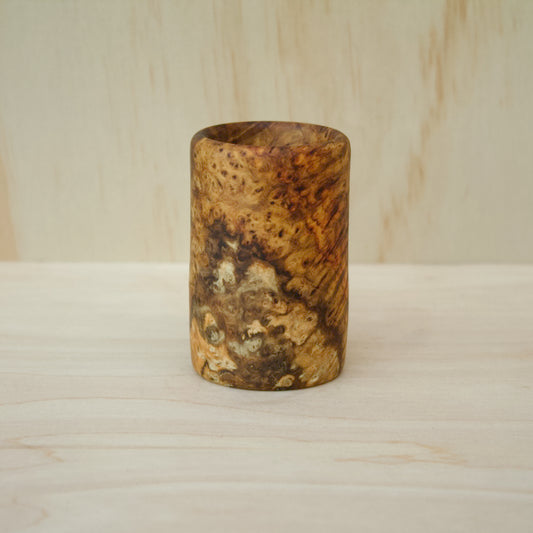 hand made wooden shot glass with rich reddish‑brown tones accented by golden streaks and intricate burl swirls