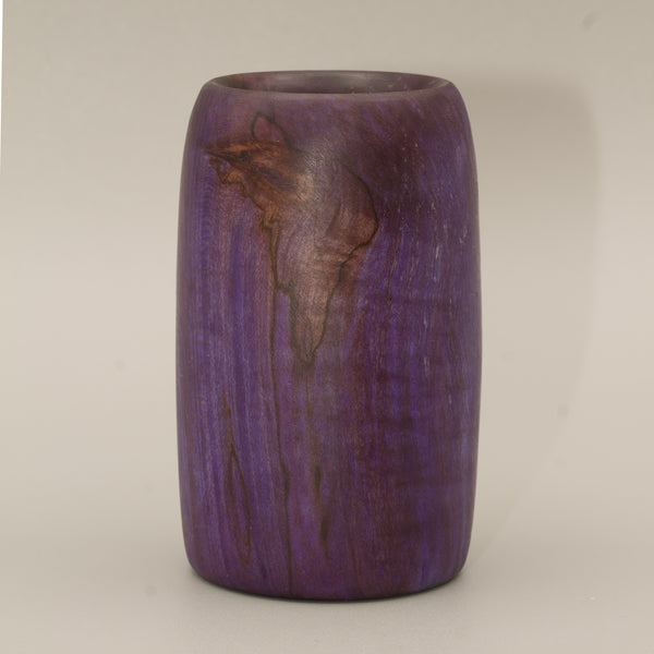 Amethyst colored wood shot glass against white background