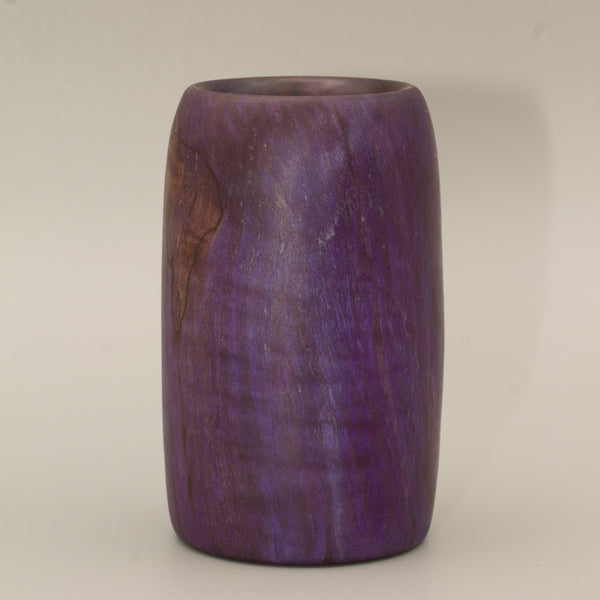 Amethyst colored wood shot glass against white background