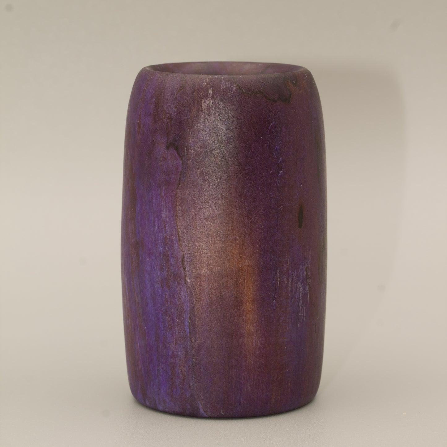 Amethyst colored wood shot glass against white background
