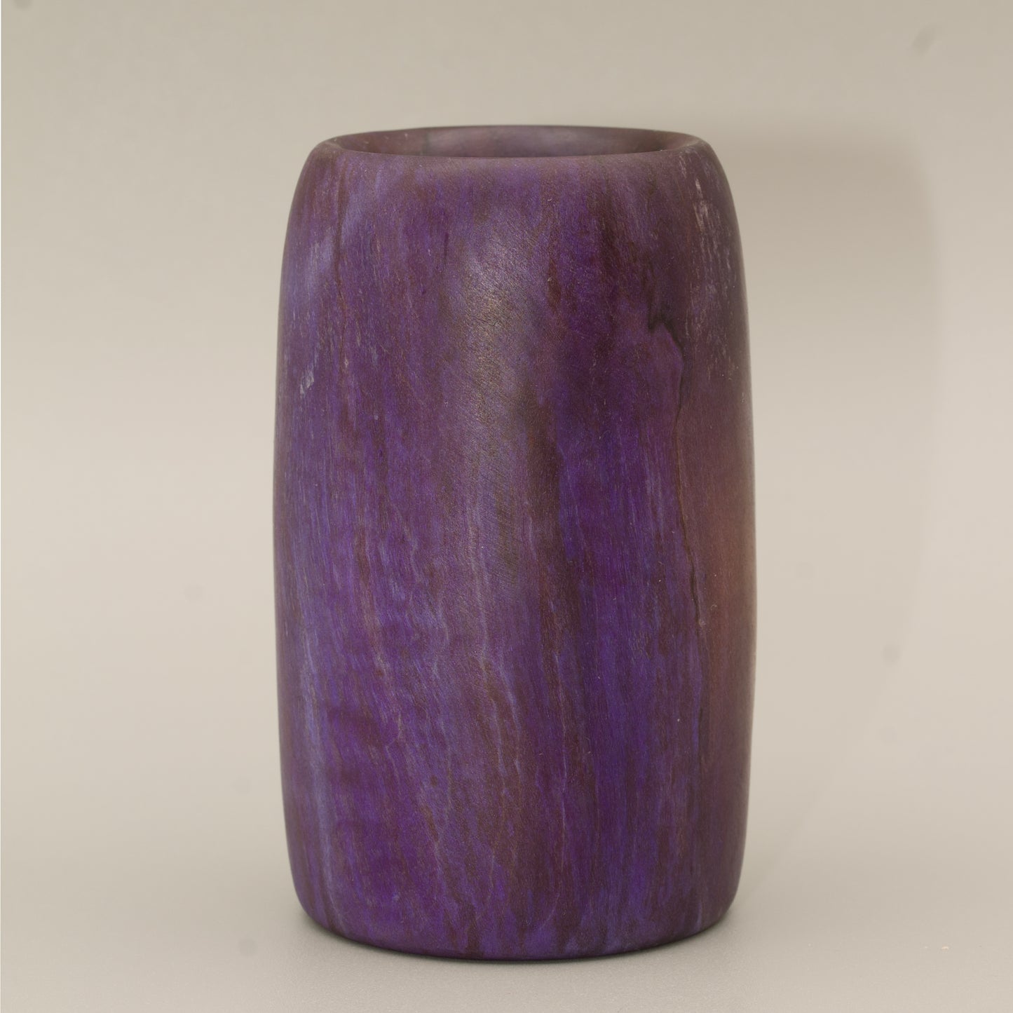 Amethyst colored wood shot glass against white background