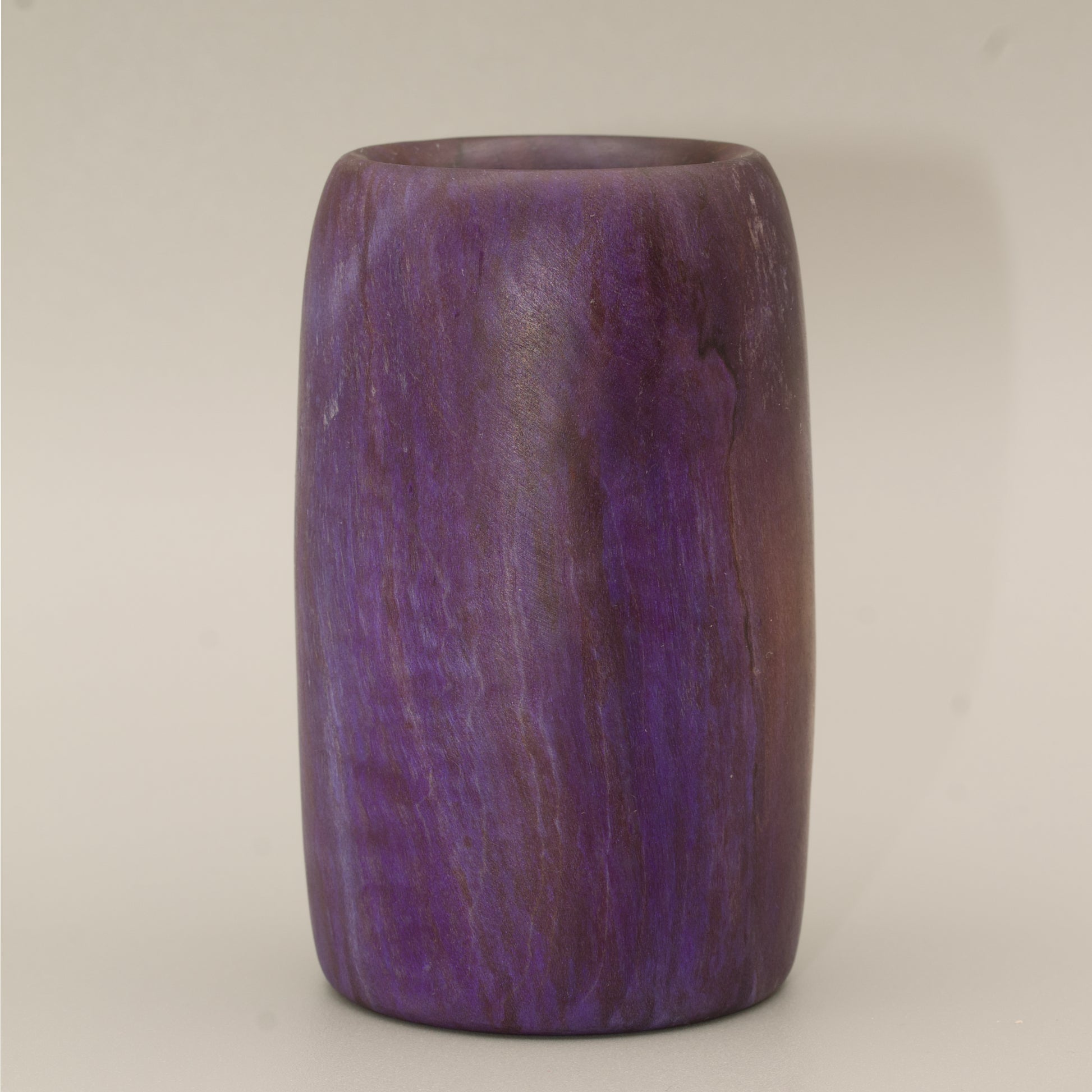 Amethyst colored wood shot glass against white background