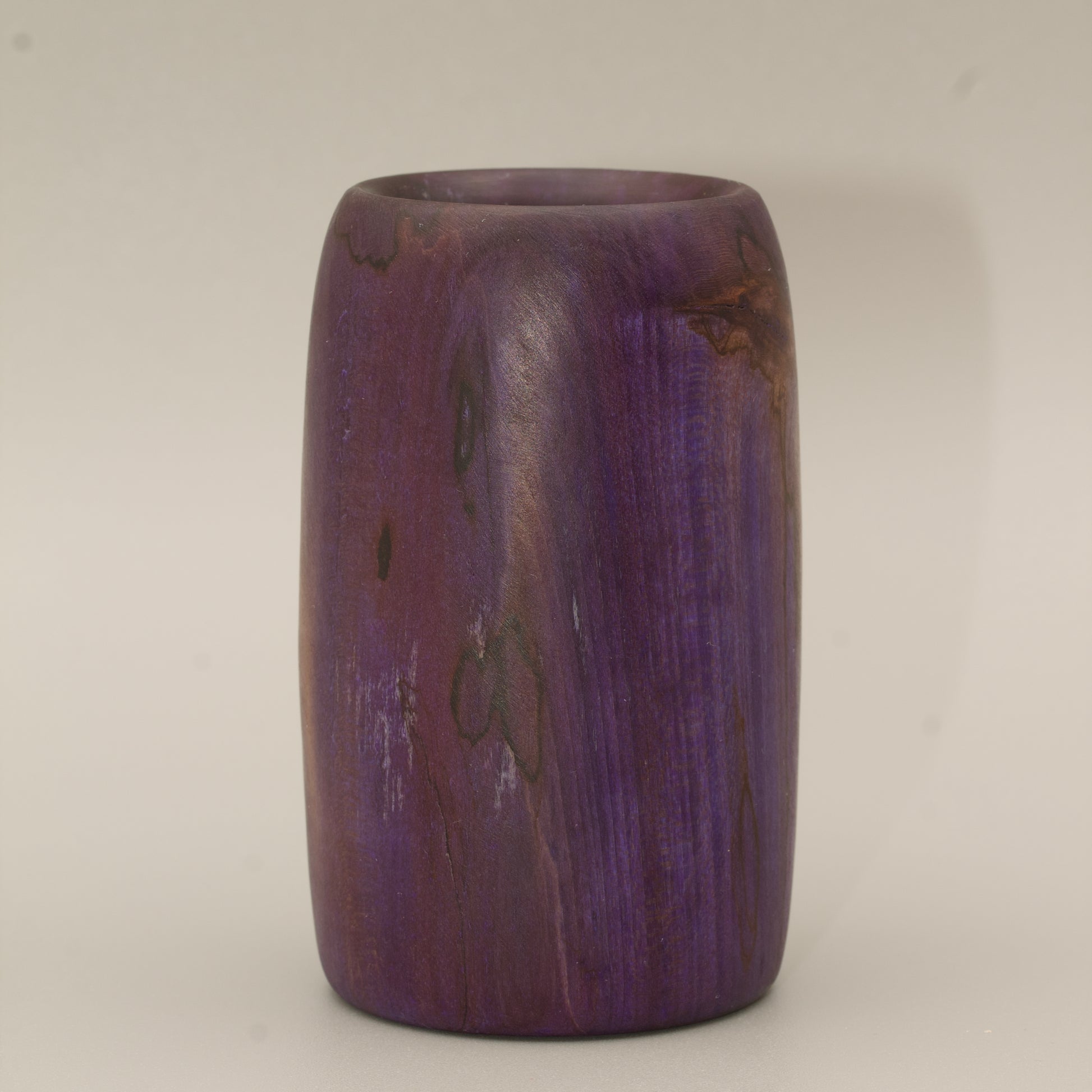 Amethyst colored wood shot glass against white background