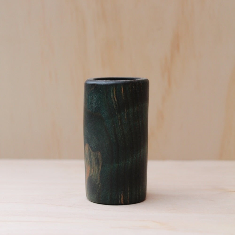 wooden shot glass made of ash wood dyed in blue on a light wood background