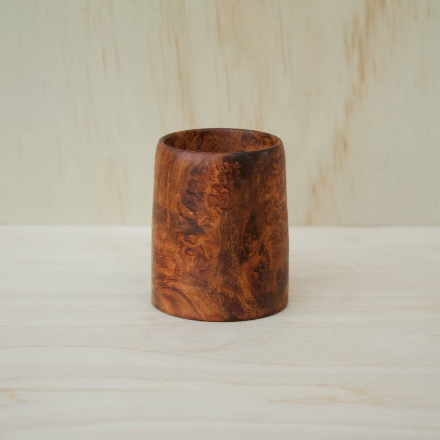 hand made wooden glass with rich reddish‑brown tones accented by lighter golden swirls
