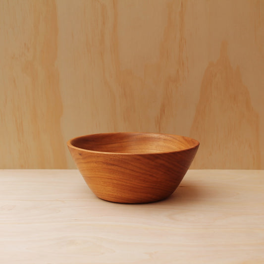 large wooden salad bowl on a light wooden background
