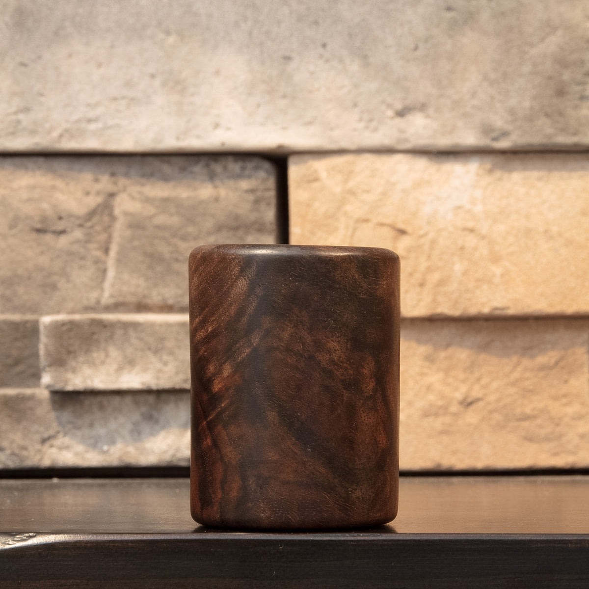 Claro Unbound shot glass showing a quieter exterior face with dark flowing Walnut grain