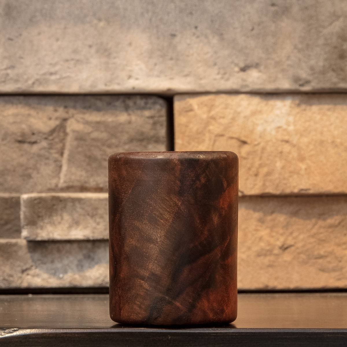 Claro Unbound Claro Walnut shot glass showing flowing diagonal grain and warm amber-brown figure