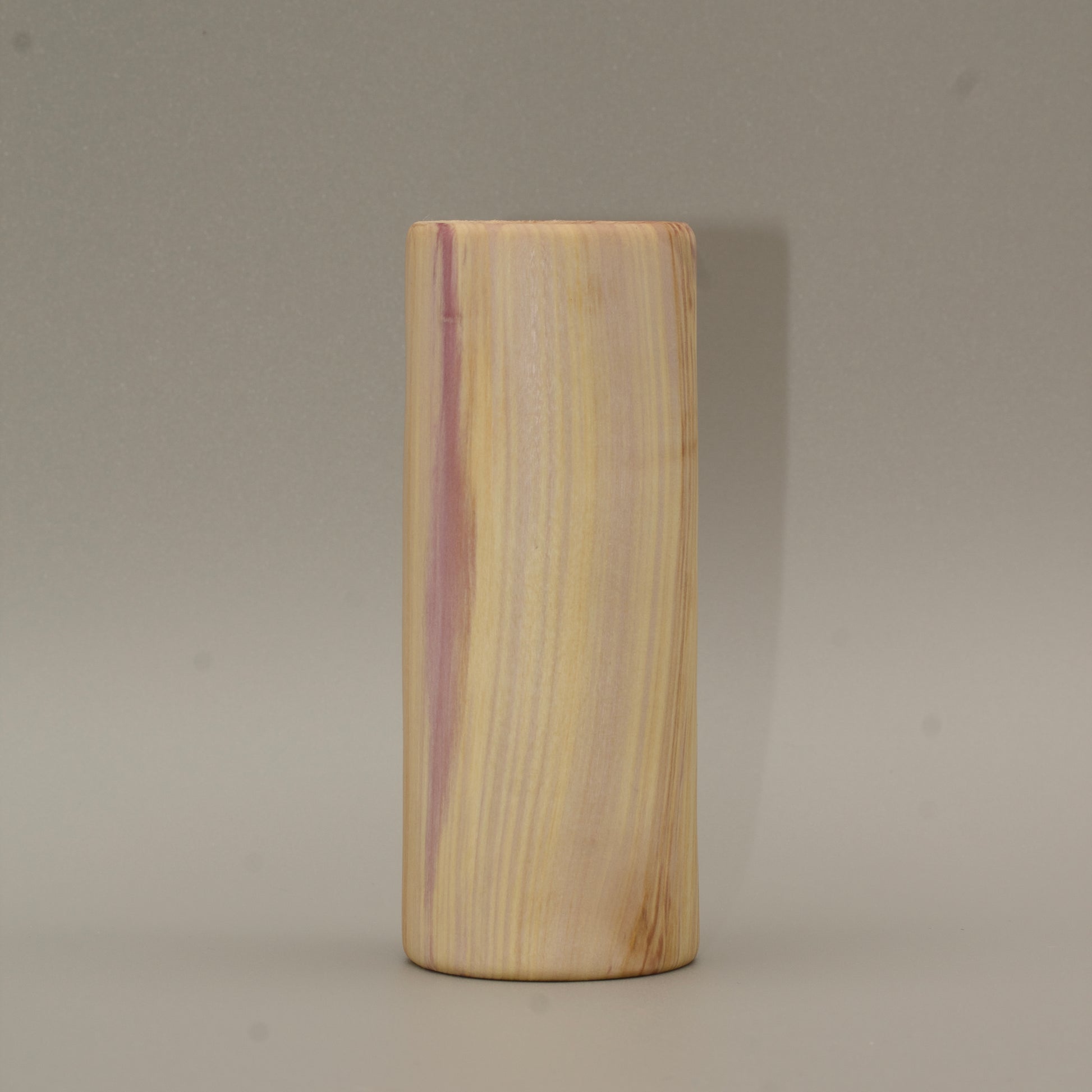 Tall rainbow colored aspen wood shot glass on white background