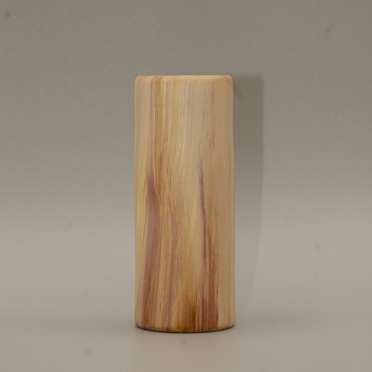 Tall rainbow colored aspen wood shot glass on white background