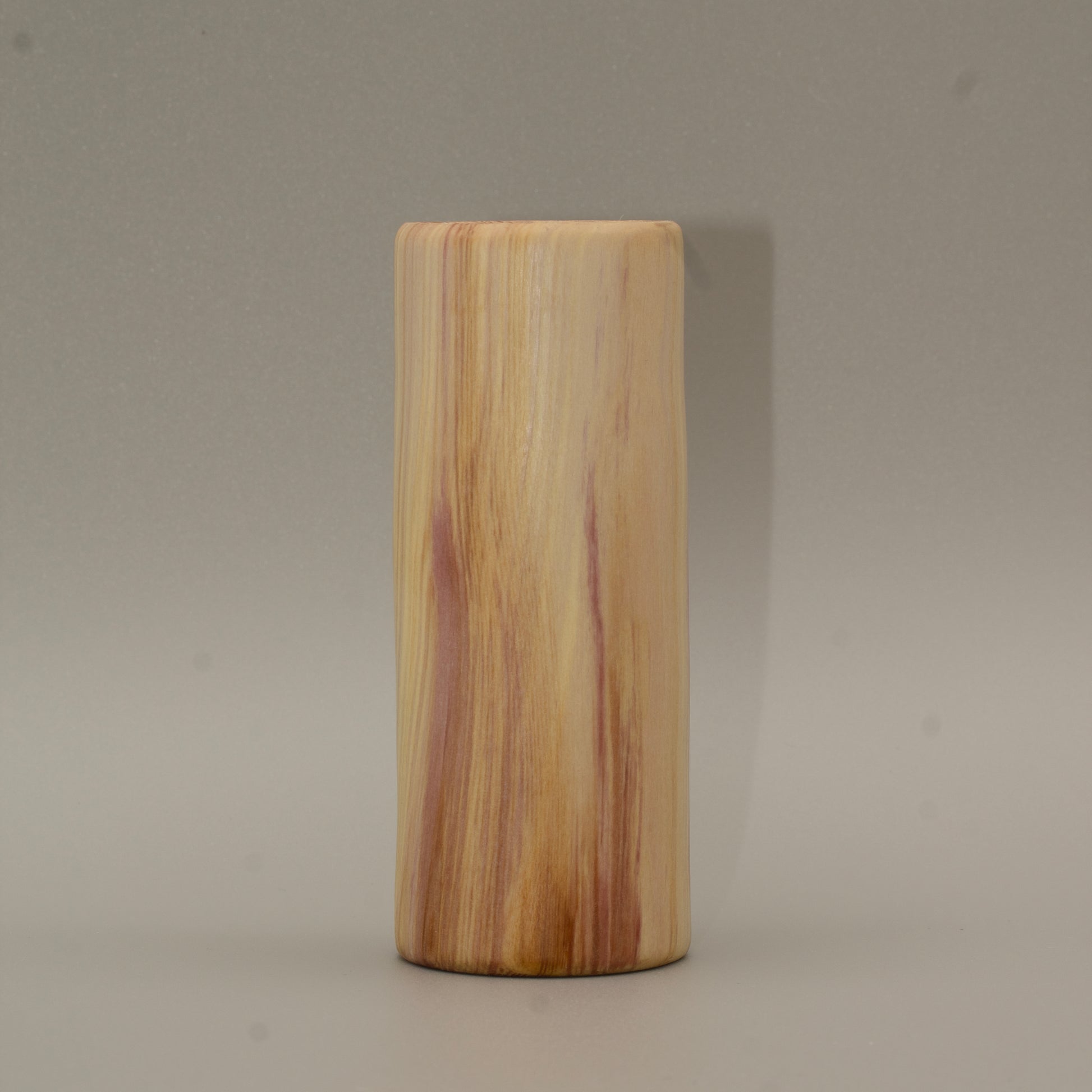 Tall rainbow colored aspen wood shot glass on white background