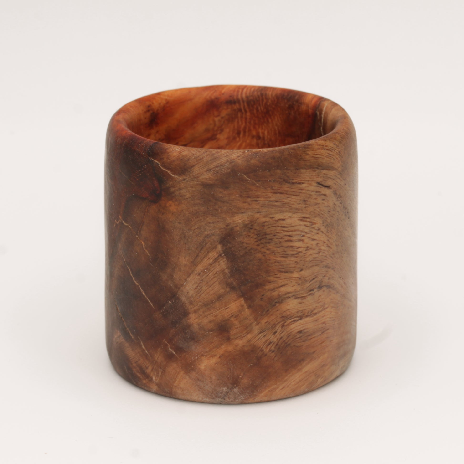 Amboyna burl shot glass against white background