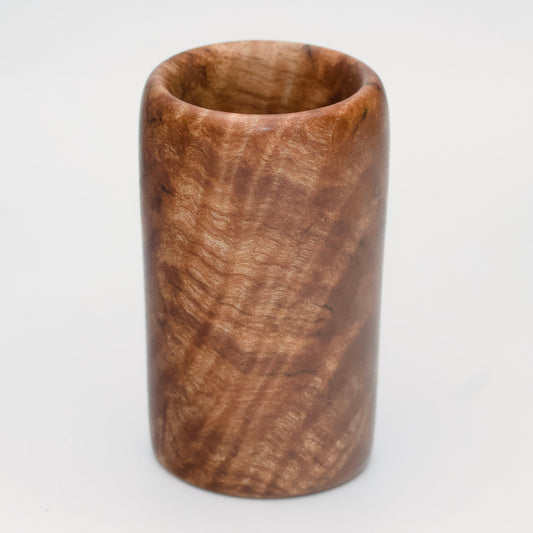 Figured maple wood shot glass against white background