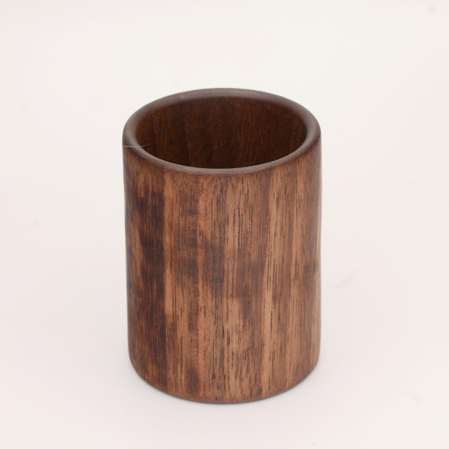 Walnut wood shot glass against white background
