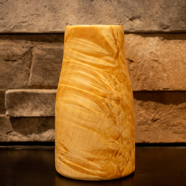 Giant box elder burl wood shot glass against a stone fireplace background