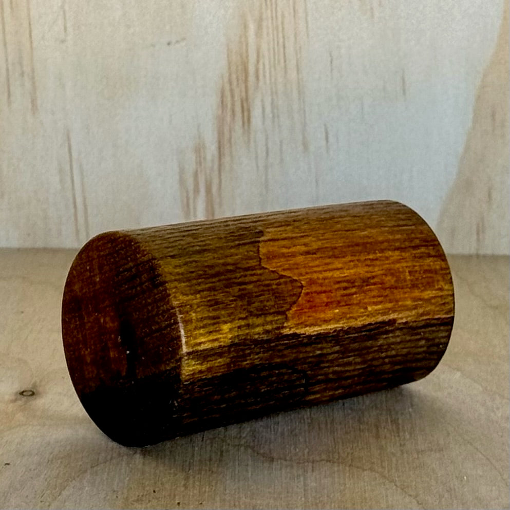 Wooden shot glass on a wooden surface with a light background