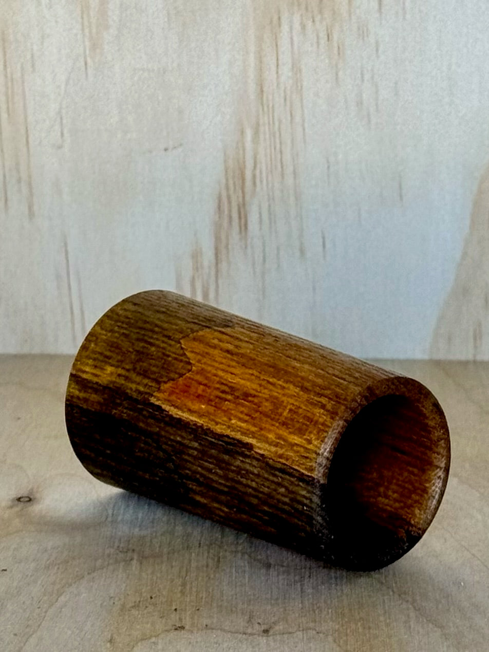 Wooden shot glass on a wooden surface with a light background