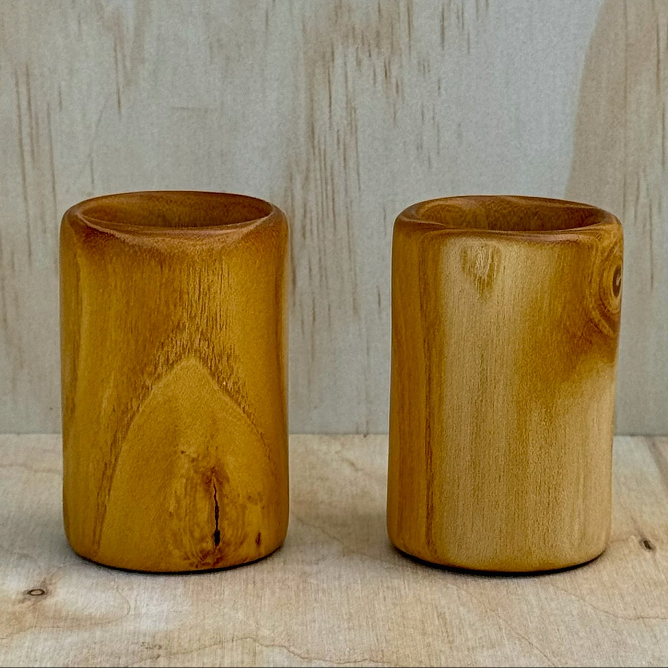 A pair of white mulberry shot glasses against a light background