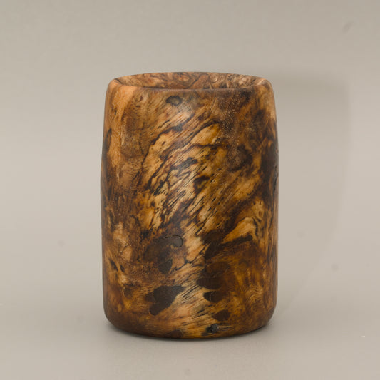 Amboyna burl striped wood shot glass against white background
