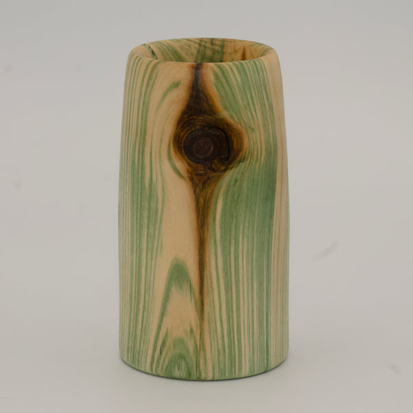 Wooden cup with green and brown marbled pattern on a wooden surface