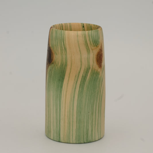 Wooden cup with green and brown marbled pattern on a wooden surface