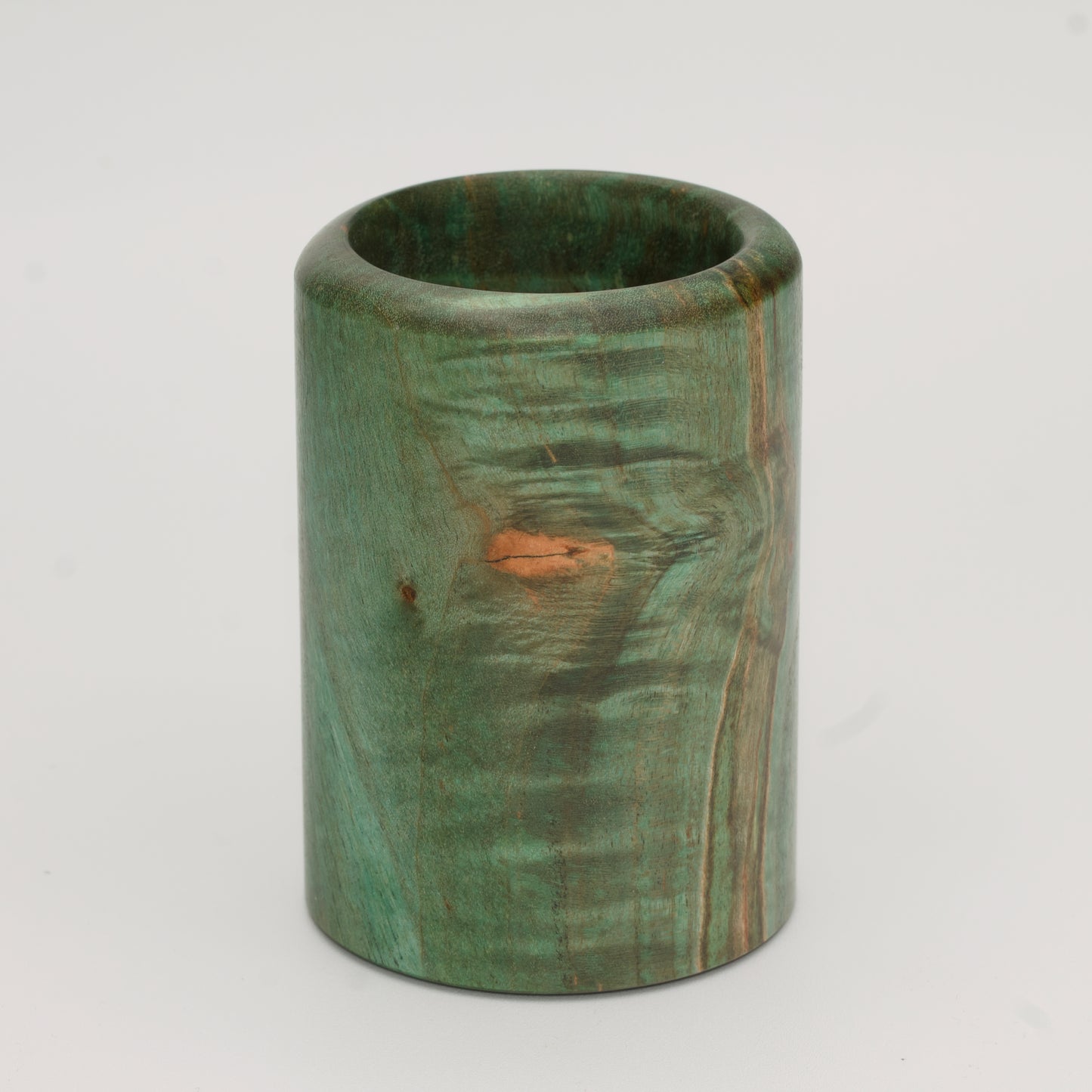Green dyed curly spalted maple burl shot glass against white background