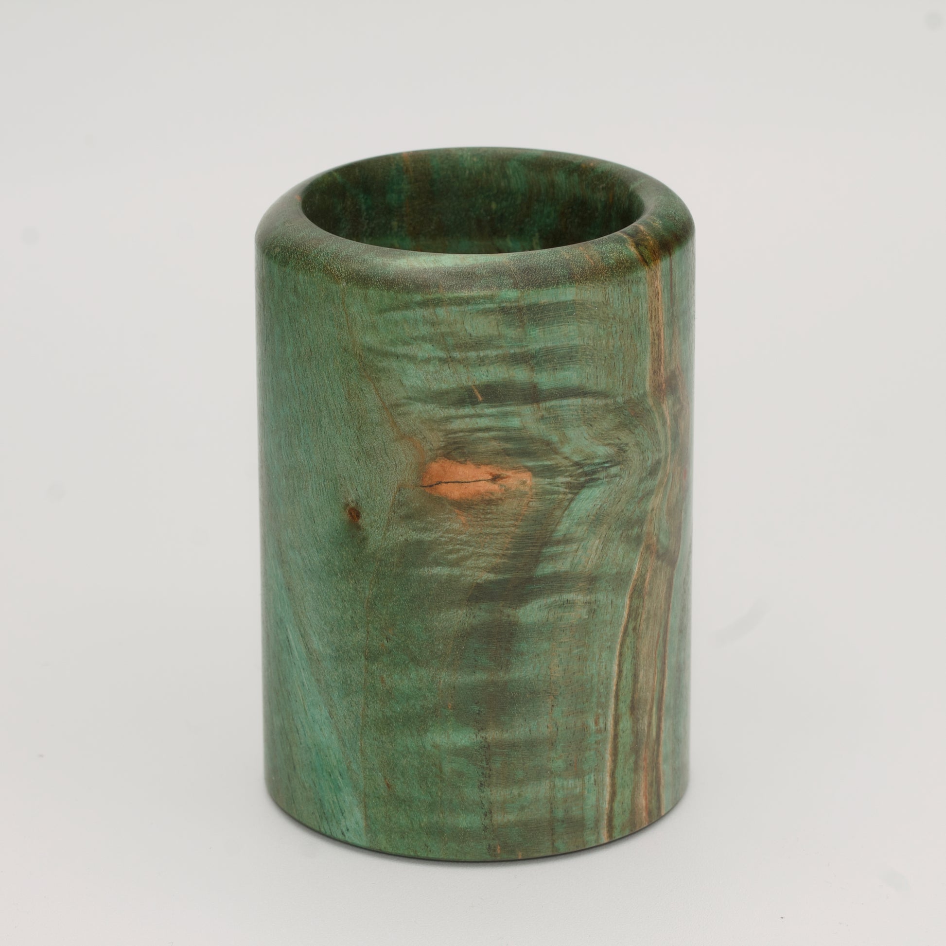Green dyed curly spalted maple burl shot glass against white background