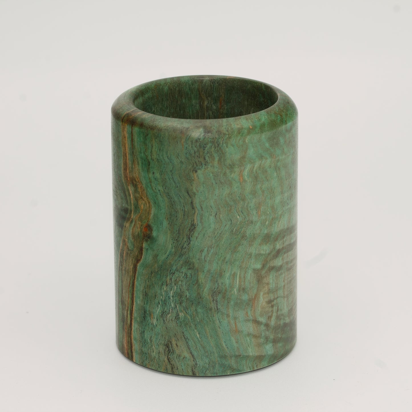 Green dyed curly spalted maple burl shot glass against white background