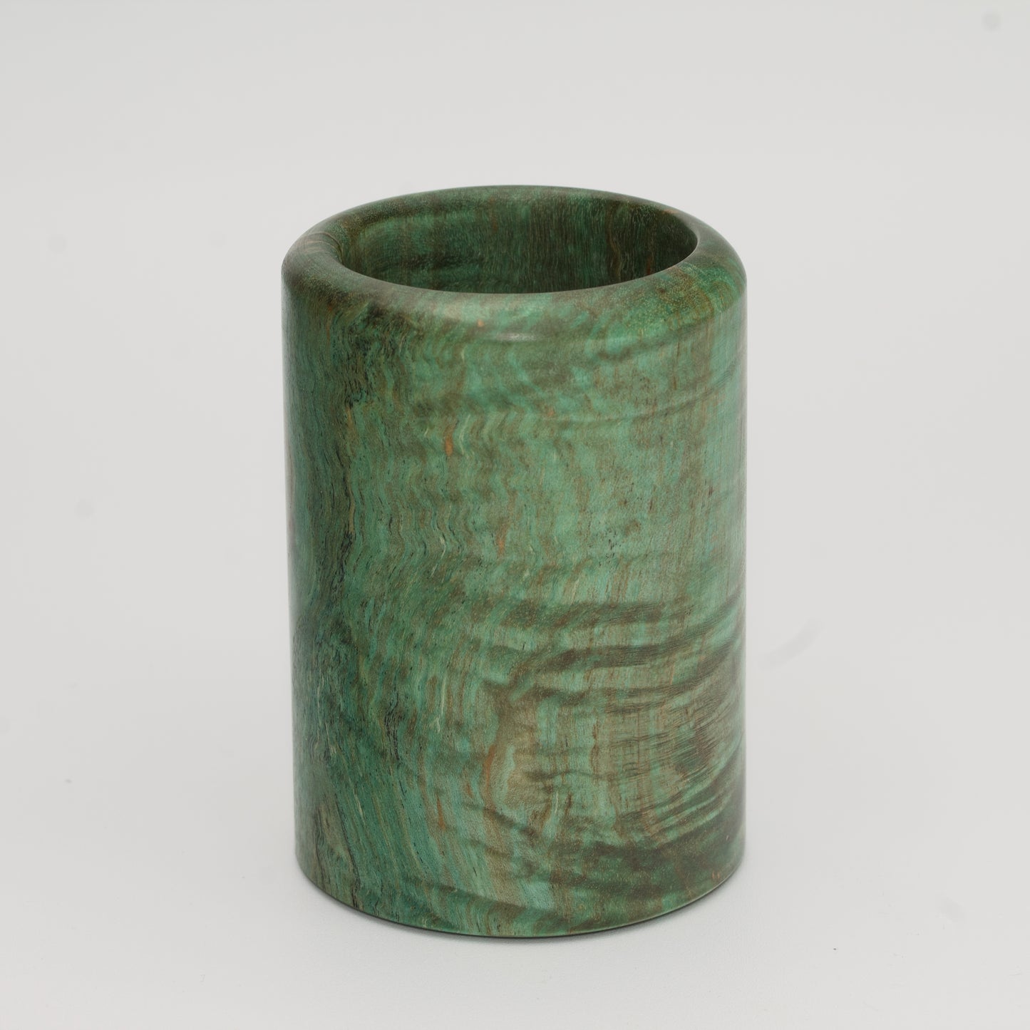Green dyed curly spalted maple burl shot glass against white background