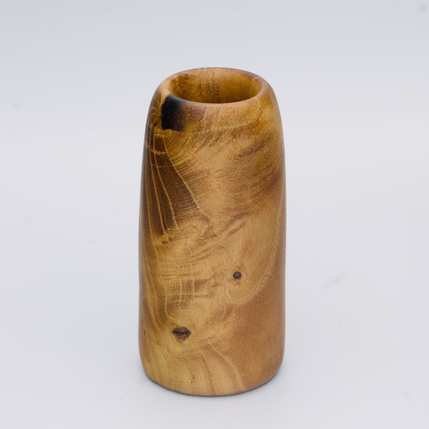 Stunning tall mulberry wood shot glass against white background