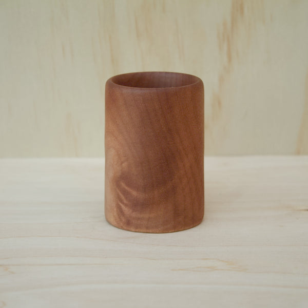 hand made wooden shot glass with golden brown tones 