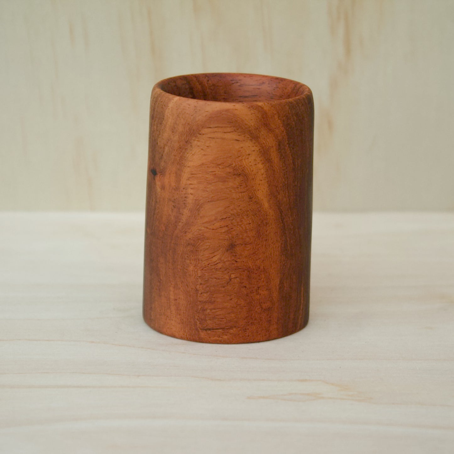 chestnut color wooden cup on a light wooden background