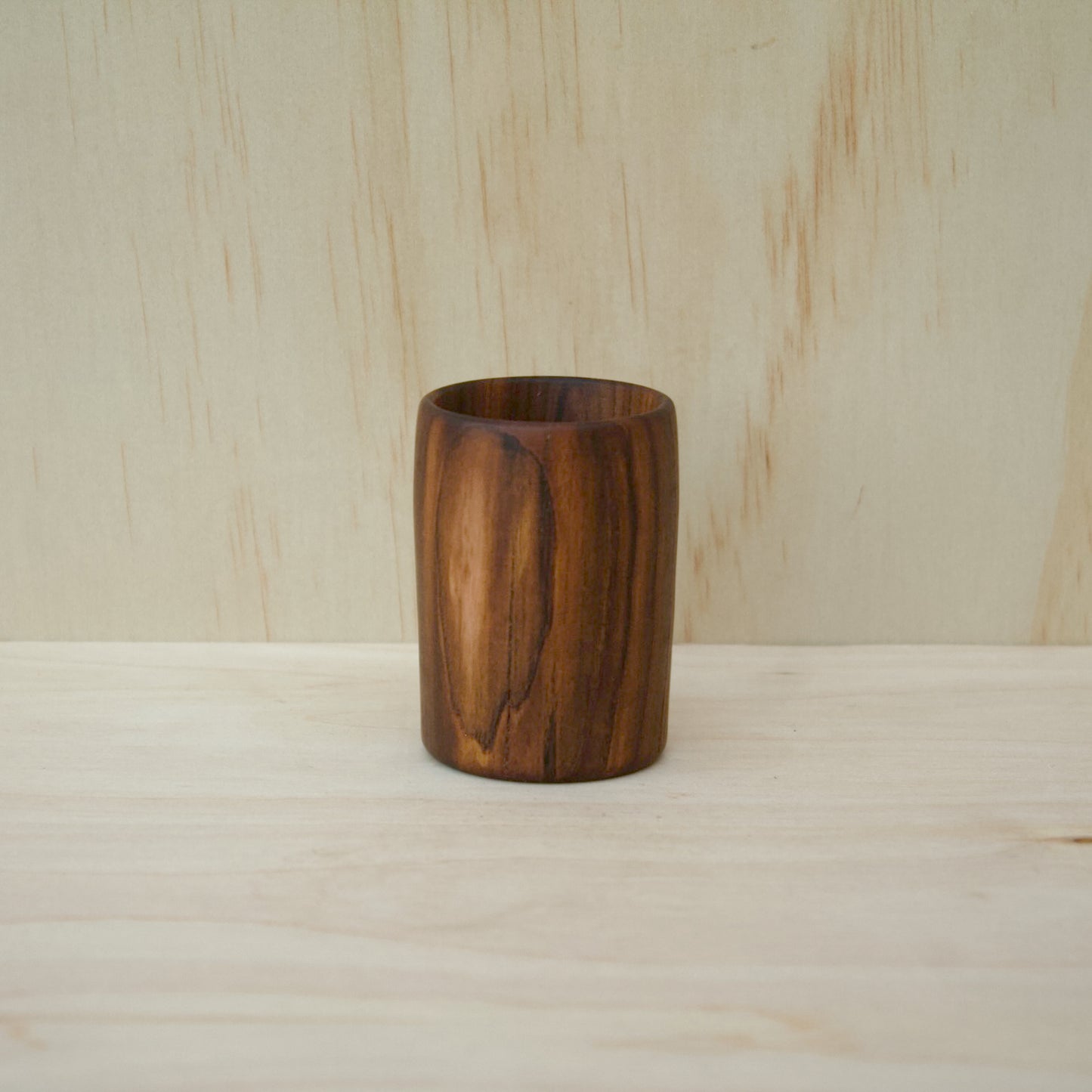 rich chocolate brown wooden cup on a light wooden surface