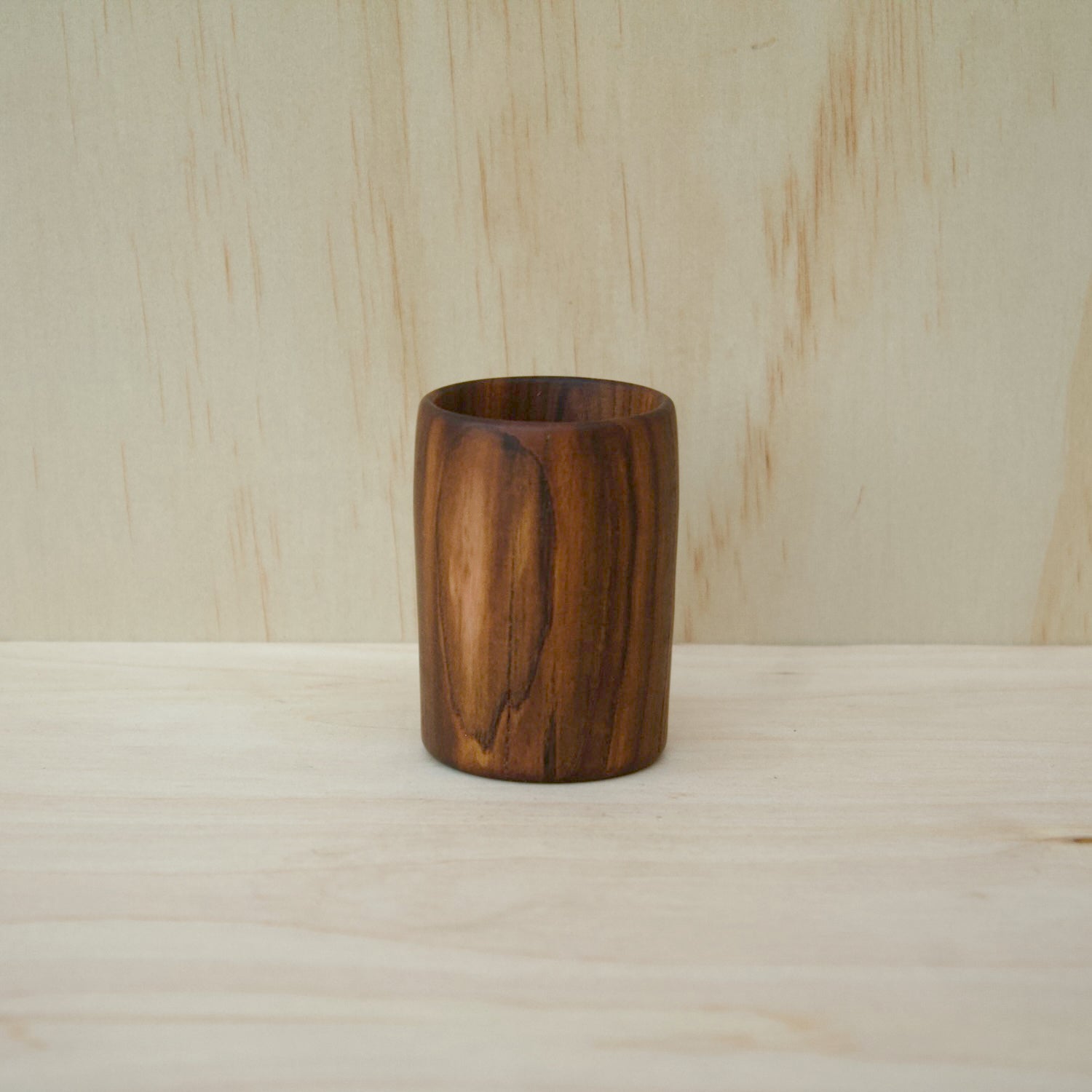 rich chocolate brown wooden cup on a light wooden surface
