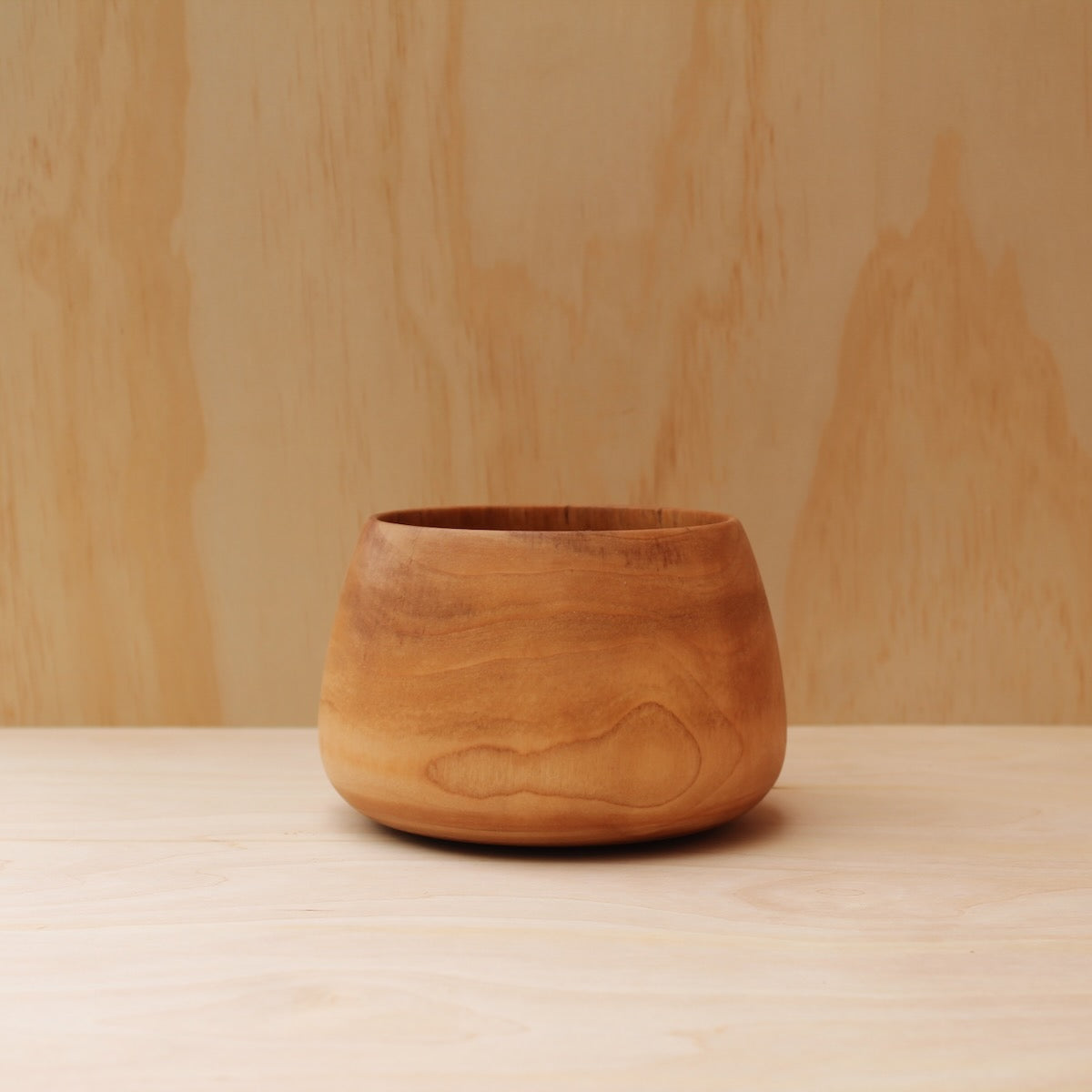 hand made wooden, deep rice bowl on a light wooden surfce