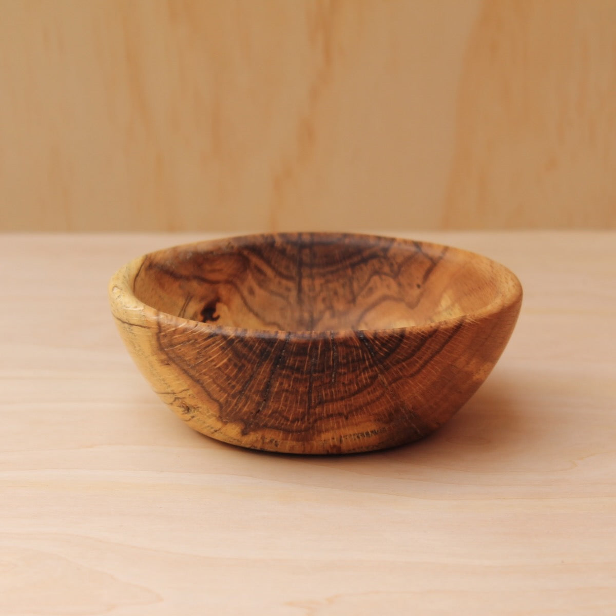 Wooden bowl on a wooden surface with a blurred background