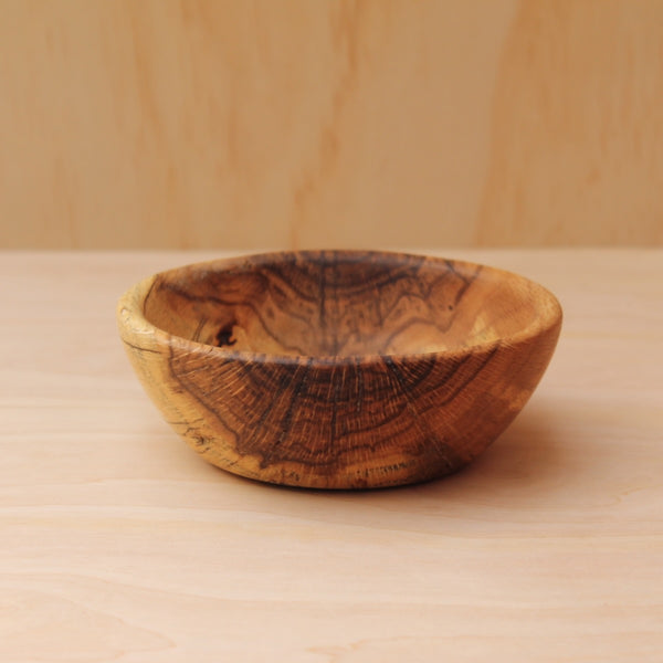Wooden bowl on a wooden surface with a blurred background