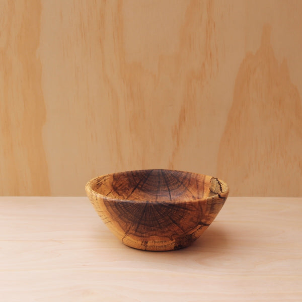 hand made wooden bowl made of rescued grain spalted oak on a light wooden background
